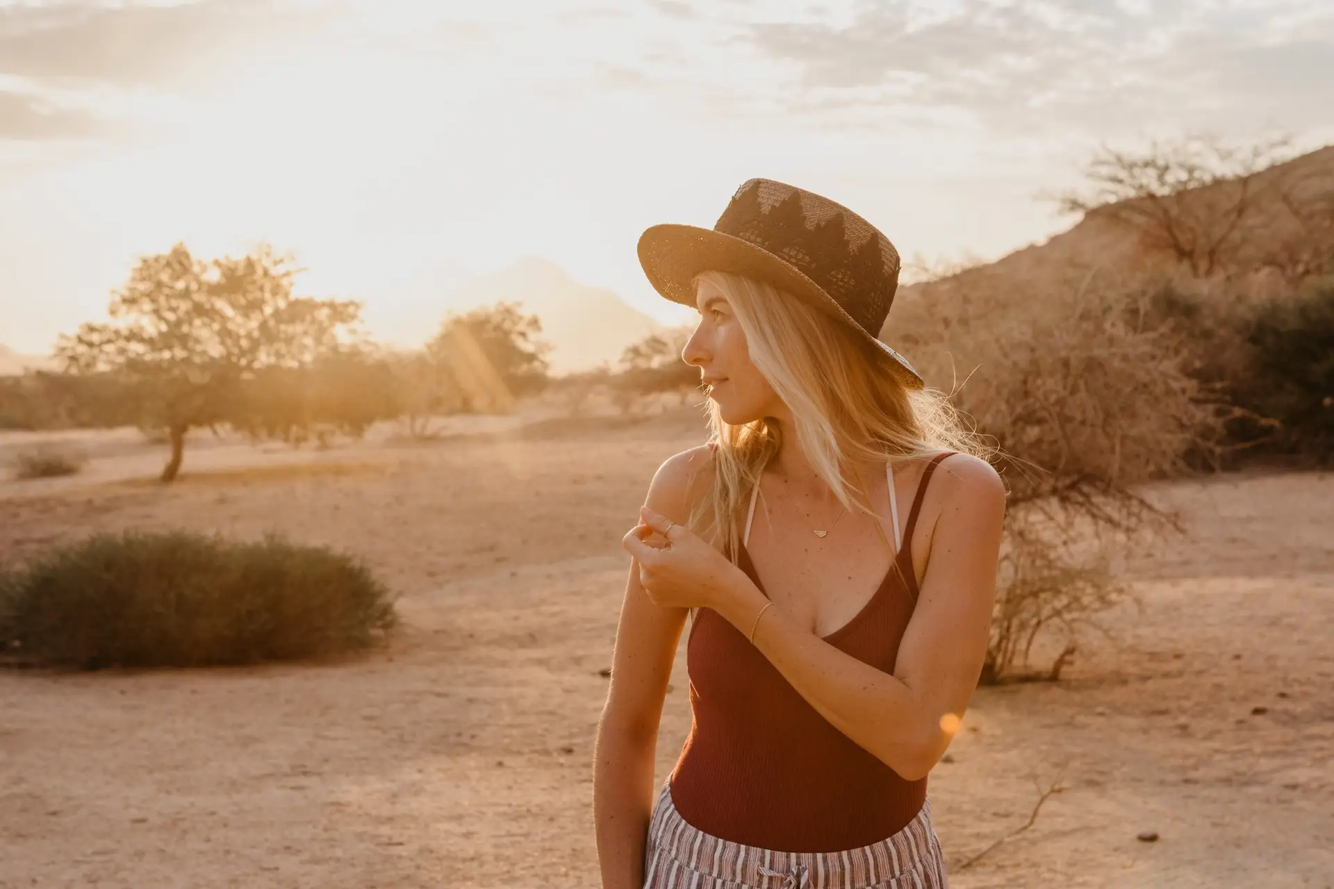 Namibia, Spitzkoppe, woman with hat at sunset